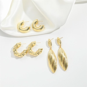 Golden C-shaped hoops and drop earrings with hammered and lava textures on silk
