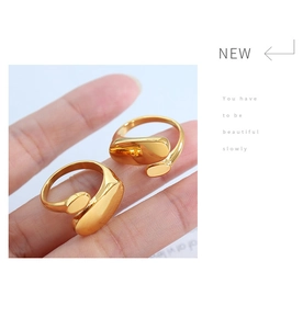Detail of minimalist 18k gold irregular streamlined open ring worn on a finger