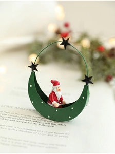 Detail of Santa Claus figure on green crescent moon metal stand with stars