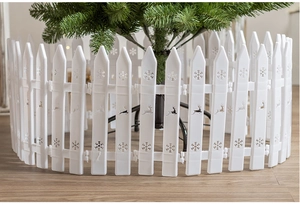 White Christmas tree fence with snowflake and reindeer patterns on wooden floor