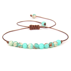 Detailed macro view of 4mm green stone beads and adjustable woven cord on the bracelet