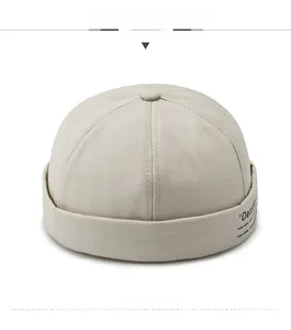 Detail of beige miki hat showing twill cotton texture and small side text embroidery