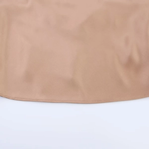 Detailed close-up of champagne satin top showing the smooth texture and fine hem stitching