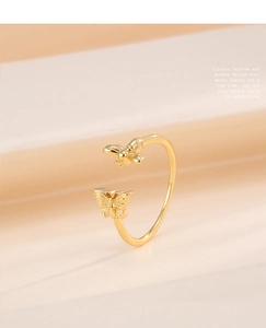 Detailed close-up of a golden adjustable ring featuring delicate butterfly and bee motifs