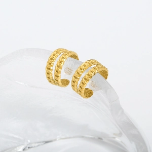 Detail of 18K gold double-layer ear cuff with woven texture on glass stand