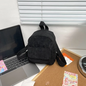 Minimalist black corduroy small backpack for women in a stylish lifestyle setting