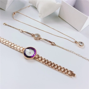 Detail of rose gold watch and jewelry set with purple faceted dial and crystal accents