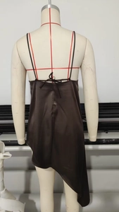 Detail of chocolate satin asymmetrical dress featuring cross back straps and open back design