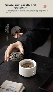 Zen style ceramic incense burner with bronze metal lid on dark wood tea table