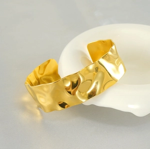 Macro shot of 18K gold plated cuff bracelet with unique hammered texture and open design