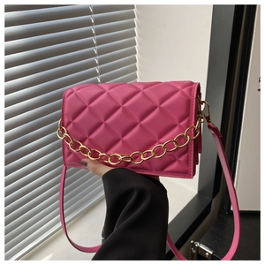 Detail of pink quilted crossbody bag with gold chain strap and textured leather finish