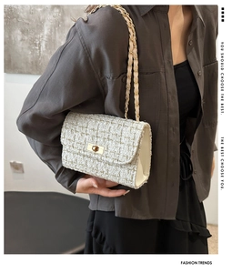Detail shot of ivory tweed crossbody bag with golden chain and metallic turn-lock