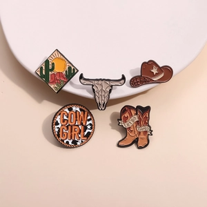 5-piece western cowboy enamel pin set with cactus, boots, and hat on white ceramic