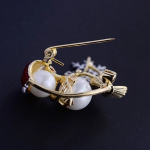 Festive Christmas brooch with white pearls, red enamel, and crystals on gold metal