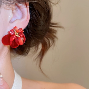 Close-up of vintage red flower earrings with coral-like petals and golden stamen detail