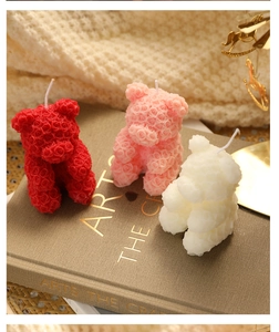 Detailed view of handmade rose bear candles in red, pink and white wax texture