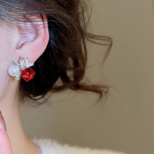 Macro detail of elegant square crystal and pearl stud earring worn on model ear