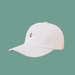 Detailed view of black embroidered letter C on a premium white cotton baseball cap