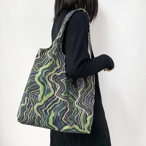 Close-up of wavy floral canvas tote bag with vibrant green and pink abstract patterns