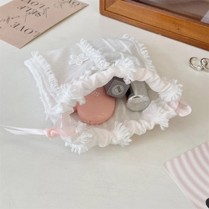 Lace drawstring pouch with pink ribbon detail showing storage capacity for cosmetics