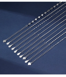 Detailed macro view of various 925 sterling silver chain styles on a dark blue surface