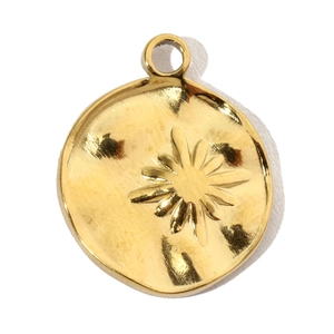 Detailed macro view of a gold-plated circular pendant with an embossed starburst pattern