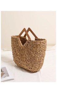 Detail of woven straw bag with gold thread highlights and unique triangular wood handle