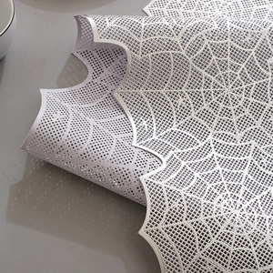 Macro detail of silver geometric cutout table runner with flexible mesh texture and patterns