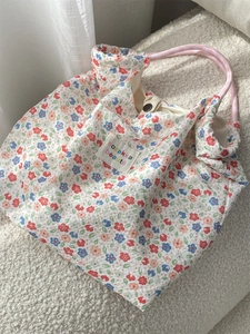 Detail of floral canvas tote with sozakka beaute label and pink woven rope handles