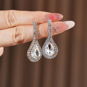 Close-up of silver teardrop earrings with sparkling crystal pavé and large drop stone