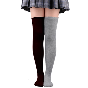 Détail de chaussettes hautes bicolores rouge et gris en maille sur un modèle