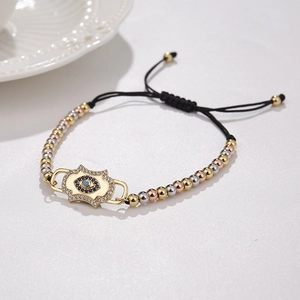 Detail of gold-plated Evil Eye charm with micro-pave zircons on adjustable black cord