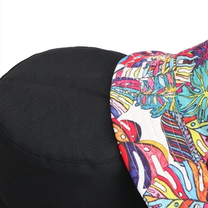 Detail of reversible bucket hat showing black twill fabric and tropical leaf floral print