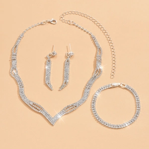 Detailed view of silver bridal jewelry set with V-shaped necklace and rhinestone drop earrings