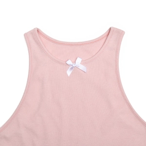 Détail de la robe rose en maille côtelée avec un petit nœud blanc satiné sur le col rond