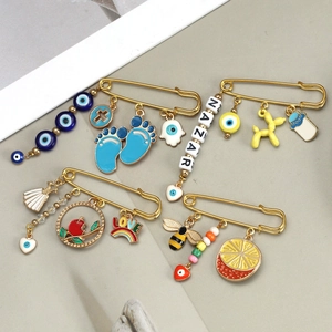 Detailed view of four golden decorative pins featuring Evil Eye and Nazar enamel charms