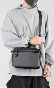 Men's nylon crossbody bag showing practical large capacity on model with grey hoodie