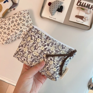 Close-up of floral cotton linen coin purse with a metal zipper and braided rope handle