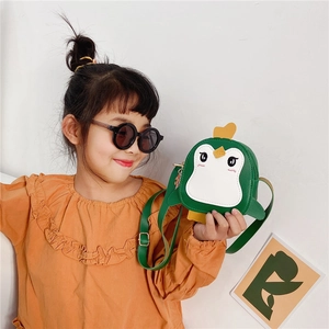Close-up of a green cartoon penguin crossbody bag with adjustable strap for kids