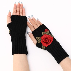 Detail of black knitted fingerless gloves with elegant red rose floral embroidery