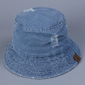 Vue détaillée du chapeau bob en denim bleu avec déchirures et patch en cuir