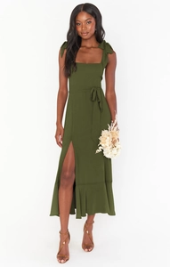 Detail of olive green maxi dress featuring shoulder ties and elegant ruffled hem slit