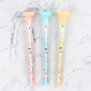 Macro detail of cute stackable bullet pencils in pink, blue, and yellow on marble