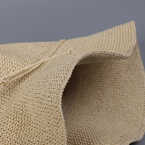 Macro detail of beige hand-woven straw hat showing fine texture and adjustable drawstring