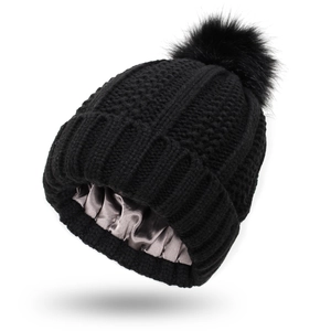 Black cable knit beanie with fluffy pom-pom and protective grey satin lining for hair