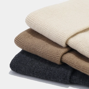 Close-up of ribbed knit beanies showing texture in beige, coffee, and dark grey colors