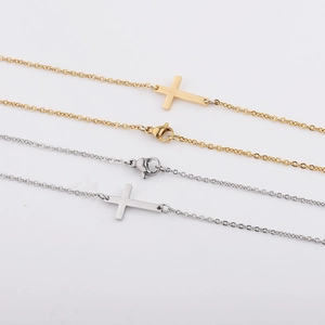 Close-up of gold and silver horizontal cross pendants on fine stainless steel chain