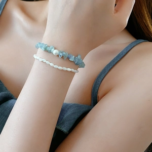 Gros plan d'un bracelet double épaisseur avec éclats de pierres bleues et perles d'eau douce