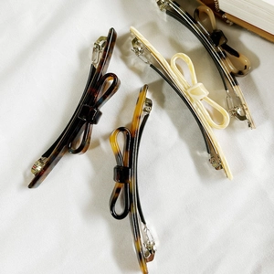 Elegant french acetate bow hair clips in amber and cream colors for stylish women