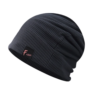 Détail d'un bonnet en maille gris foncé avec broderie fashion sur un patch carré